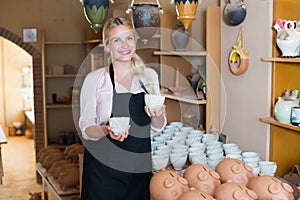 Laughing woman carrying ceramic vessels