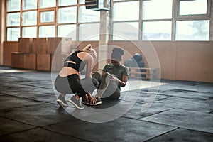 Laughing woman doing sit-ups in a gym with a partner