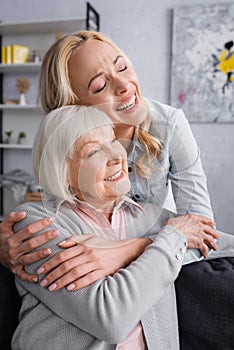 Laughing woman embracing senior mother in