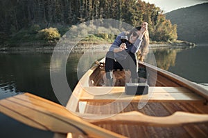 Laughing woman enjoy canoe ride with glass of wine