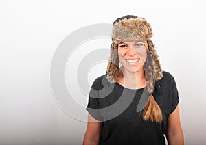 Laughing woman in grey t-shirt and winter hat