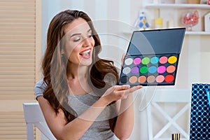 Laughing woman holding eyeshadow set