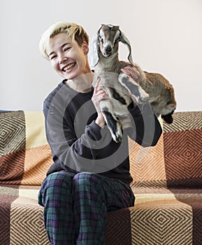 Laughing woman holding a little goat