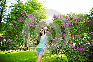 Laughing woman with long healthy hair in the park on a lilac background.