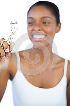 Laughing woman looking at her eyelash curler