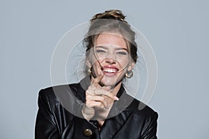 Laughing woman pointing finger. Portrait of happy smiling girl. Cheerful young beautiful girl smiling laughing, studio
