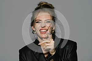 Laughing woman pointing finger. Portrait of happy smiling girl. Cheerful young beautiful girl smiling laughing, studio