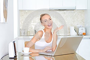 Laughing woman sitting at laptop computer