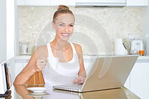 Laughing woman sitting at laptop computer