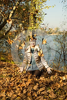 Laughing woman tossing leaves