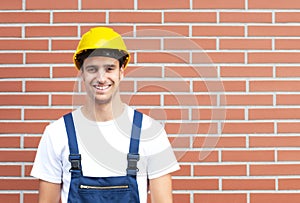 Laughing worker in front of a brick wall