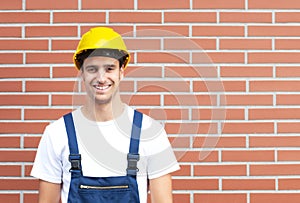 Laughing worker in front of a brick wall photo