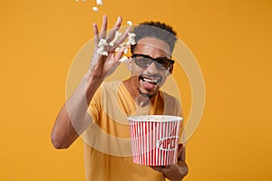 Laughing young african american guy in 3d imax glasses posing isolated on yellow orange background. People lifestyle photo