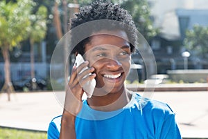 Laughing young african american man at mobile phone