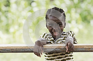 Laughing young African girl sitting in her desk