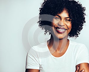 Laughing young African woman standing confidently with her arms