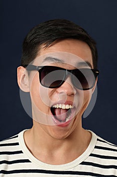 Laughing young Asian man in sunglasses