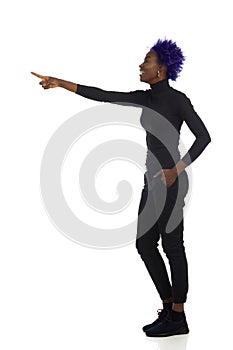 Laughing Young Black Woman Is Standing And Pointing. Side View. Full Length, Isolated