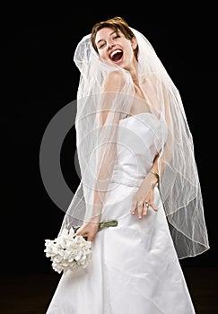 Laughing young bride in wedding dress and veil