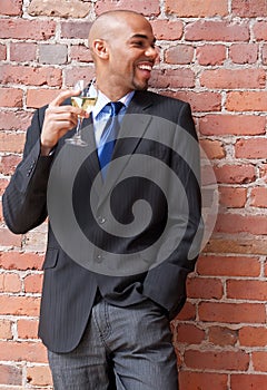 Laughing young businessman with a glass of wine