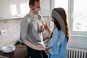 Laughing young couple dating with champagne at home