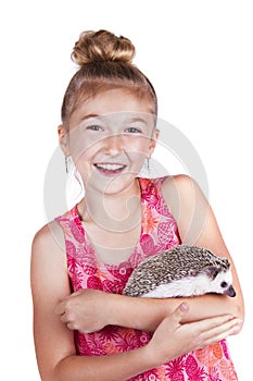 A laughing young girl having fun with her pet hedgehog