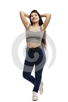 Laughing young girl in jeans. Brunette with long hair. Isolated on a white background. Vertical. Full height