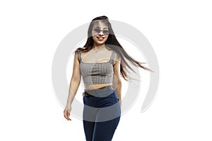 Laughing young girl in jeans. Brunette with long hair wearing sun glasses. Isolated on a white background