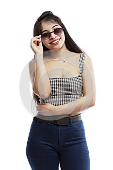 Laughing young girl in jeans. Brunette with long hair wearing sun glasses. Isolated on a white background. Vertical