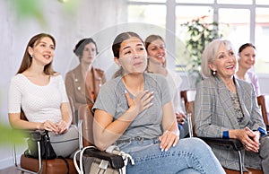 Laughing young girl listening to lecturer with group of women