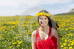 Laughing young girl posing in dandelion meadow