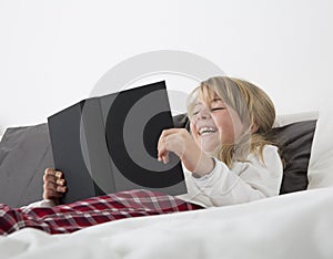 Laughing Young Girl Reading a book