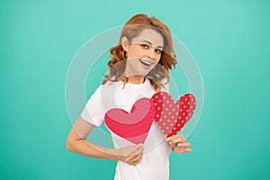 laughing young girl with red heart on blue background