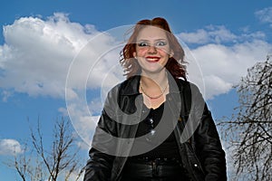 Laughing young girl stands with wide eyes against a blue sky