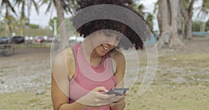 Laughing young girl taking selfie in park