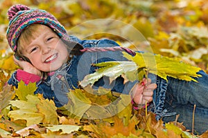 Laughing young girl on the yellow leaves