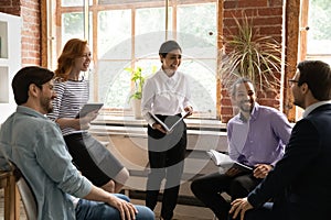 Laughing young indian business lady having fun with diverse colleagues.