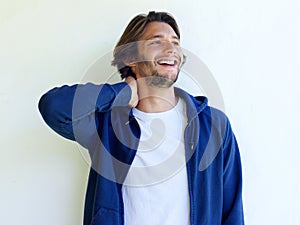 Laughing young man with hand behind head