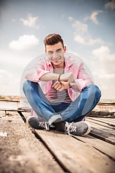 Laughing young man sitting on the floor