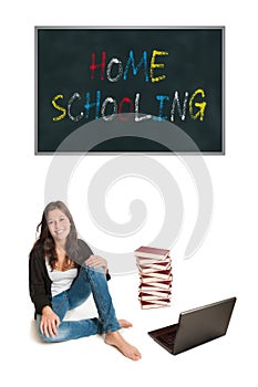 Laughing young student or elder schoolgirl with a huge pile of books and a laptop in front of a blackboard