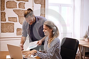 Laughing young team looking at laptop