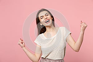 Laughing young woman in casual light clothes posing isolated on pastel pink background, studio portrait. People sincere