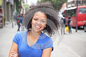 Laughing young woman with curly hair in the city