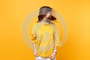 Laughing young woman in fur sweater, heart orange glasses fooling around in studio with volant hair isolated on bright photo