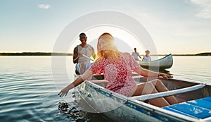 Laughing young woman having fun with friends in a lake