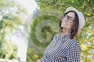 Laughing young woman looking to side or something in front of blurred nature background