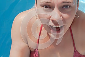 Laughing young woman in the pool, close-up portrait