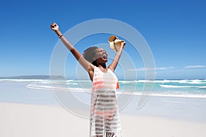 Laughing young woman standing on beach