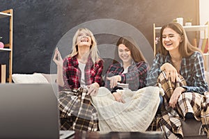 Laughing young women watching movie at home