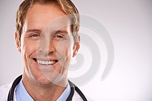 Laughter is the best medicine. Cropped studio portrait of a handsome male doctor looking pleased.